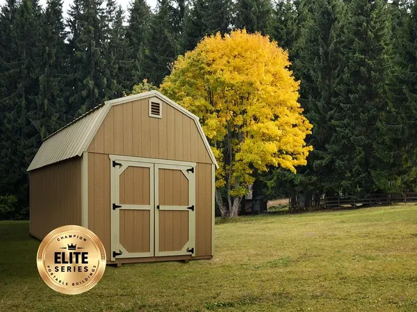 Elite Series Lofted Barn in tan beside a yellow autumn tree